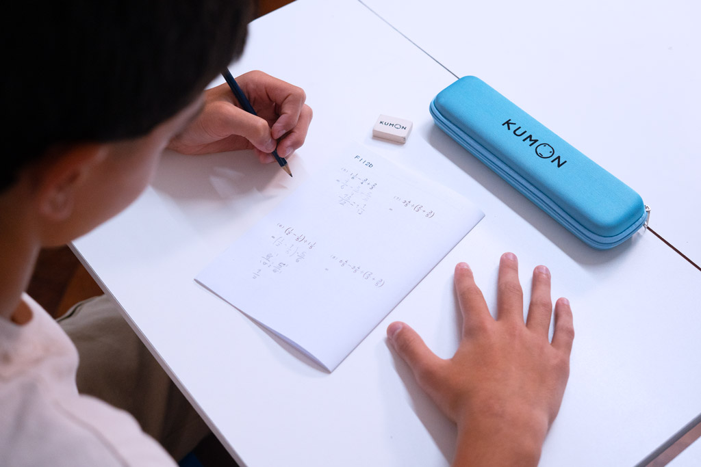 Alumno resolviendo ejercicios avanzados de matemáticas en un cuaderno Kumon, siguiendo un aprendizaje gradual y estructurado-Uruguay