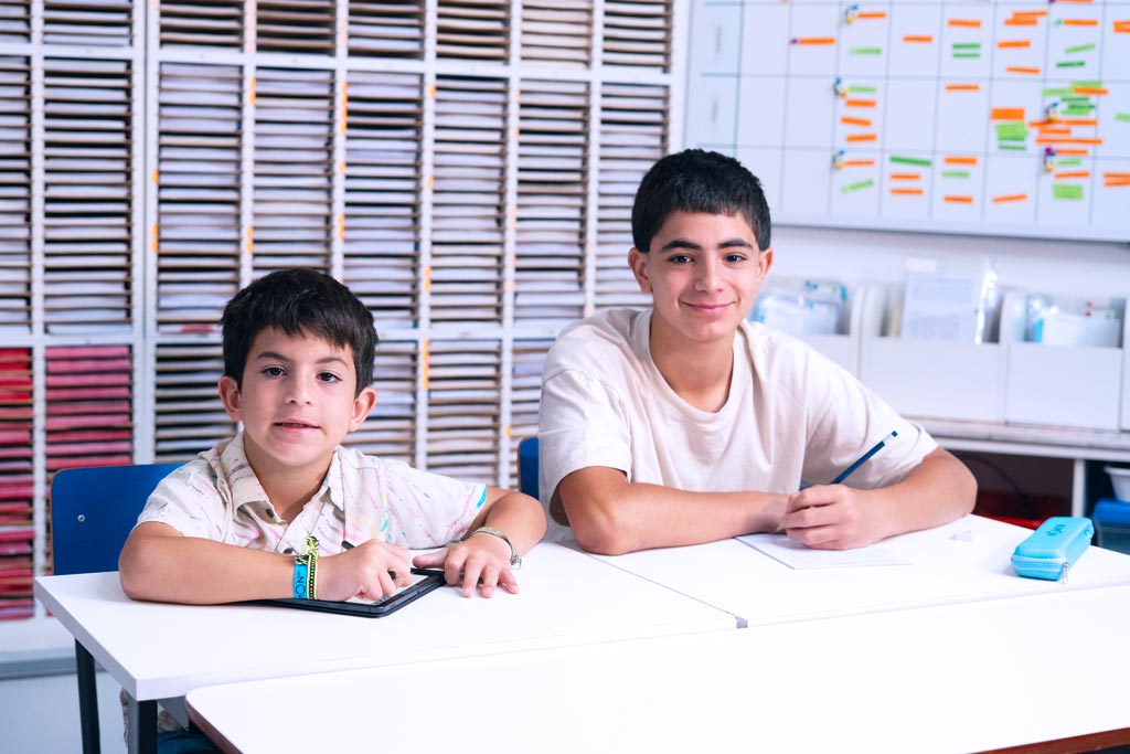 Dos alumnos en un centro Kumon, uno en la tableta y otro en el cuadernillo en papel-Uruguay