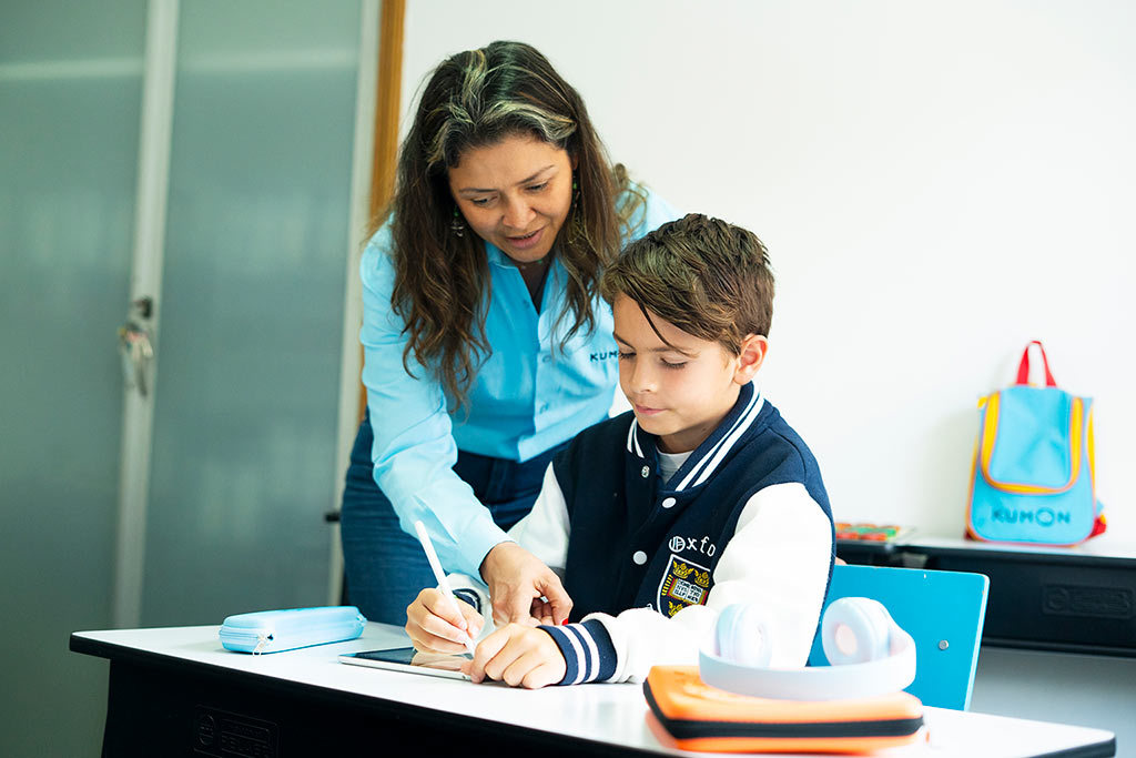 Orientadora de Kumon guiando a um alumno mientras trabaja en tableta-Uruguay