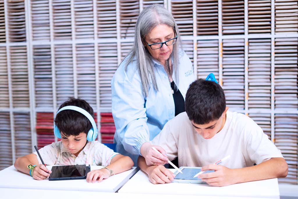 Alumnos estudiando con concentración y buena postura mientras la orientadora les da una orientación